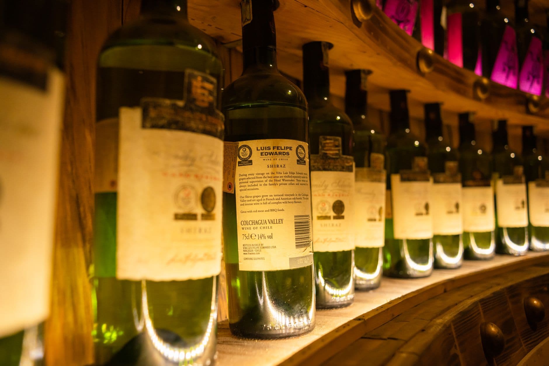 Row of wine bottles in a warmly lit wine cellar, showcasing labels and ambiance. — Photo by Toàn Văn on Pexels